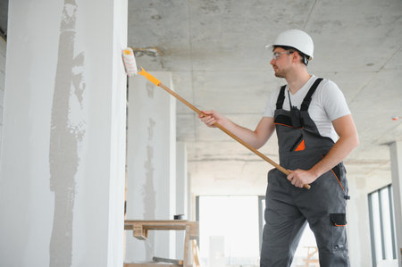painter man painting the wall, with paint roller.の写真素材