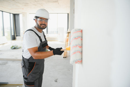 Painter painting the office wall with roller paint.