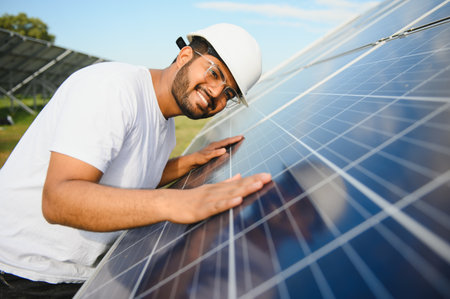 Male arab engineer standing on field with rows of solar panels.の写真素材