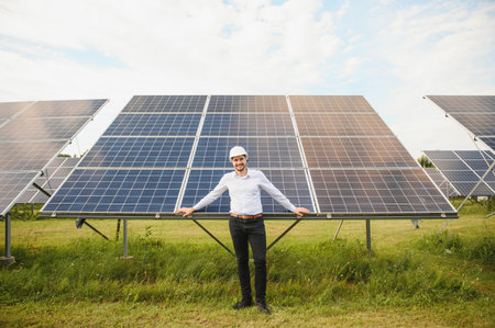 Male engineer in glasses and formal white shirt monitoring system of solar panels.の写真素材