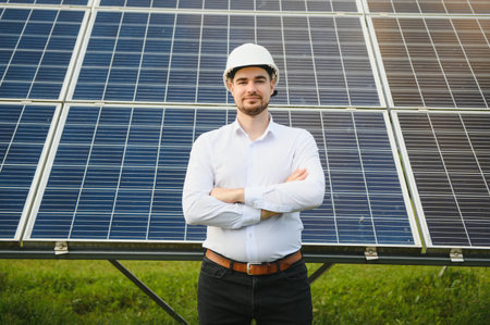 Engineer man in helmet in the field of solar panels.