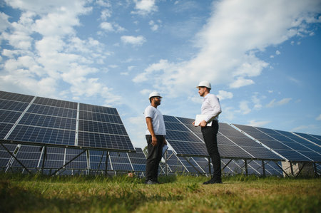 The solar farm, solar panel with two engineers walk to check the operation of the system, Alternative energy to conserve the world's energy, Photovoltaic module idea for clean energy productionの写真素材