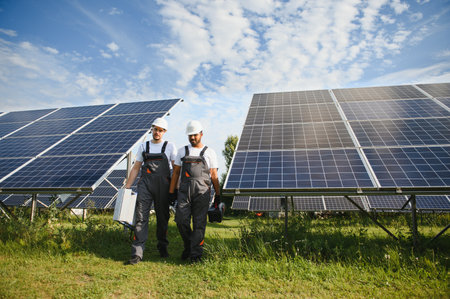 Engineer worker working in solar panels power farm. Two technician working at solar power station.