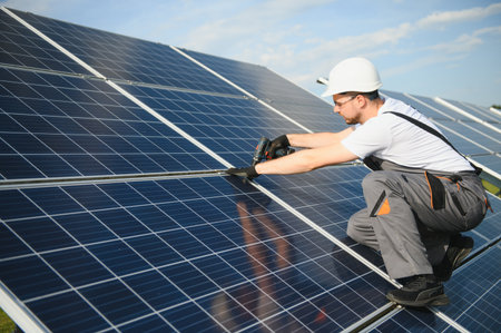 Man mounting technician photovoltaic solar modules. Engineer in helmet installing solar panel system...