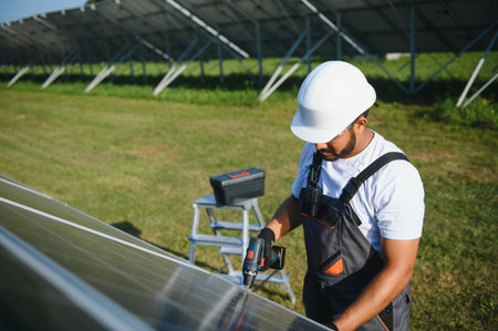 Indian worker installing solar panels. Concept of alternative, renewable energy.