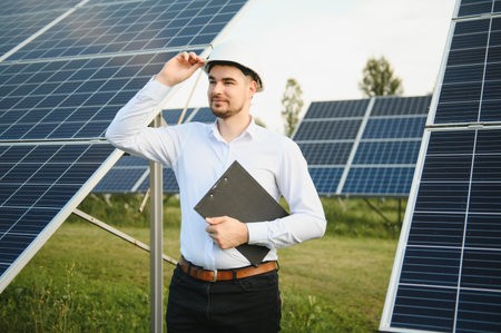 Engineer man in helmet in the field of solar panels.の写真素材