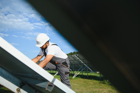 Indian worker installing solar panels. Concept of alternative, renewable energy.