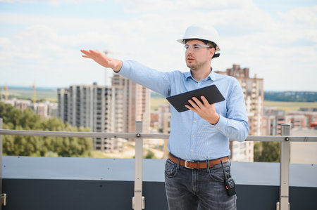Engineer with tablet, building inspection. Construction man in helmet build new house.