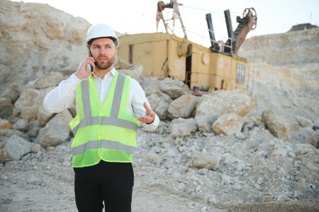 Extraction of stone. Male worker next to stone quarry. Engineer at construction site.