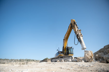 Excavator with hydraulic hammer on road construction works.