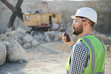 Worker in hardhat standing in stone quarry.の写真素材