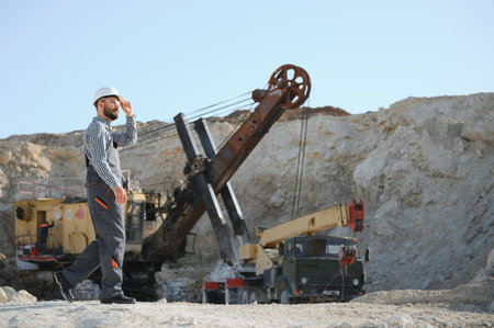 Male worker with bulldozer in sand quarry.