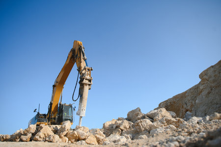 Excavator with hydraulic hammer on road construction works.