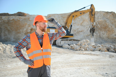 Extraction of stone. Male worker next to stone quarry. Engineer at construction site.