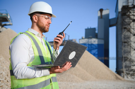 A worker in a hard hat stands with a walkie-talkieの写真素材