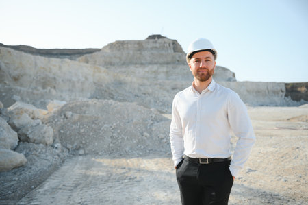Worker in hardhat standing in stone quarry.の写真素材