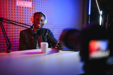 Handsome Young African American Man Talking Into Microphone While Recording Radio Show.の写真素材