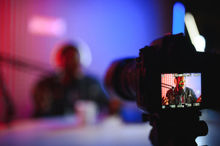 Male lifestyle vlogger recording live podcast vlog on camera.の写真素材
