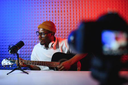 african american man with guitar in recording studio.の写真素材