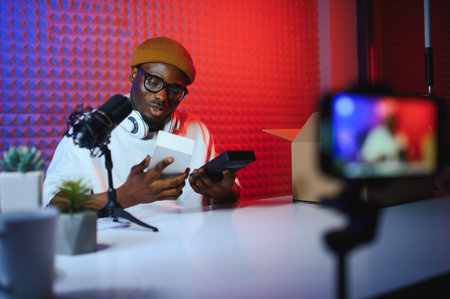 young adult man creating online content for the channel, daily vlog, unboxing a brand new phone, online sales.の写真素材