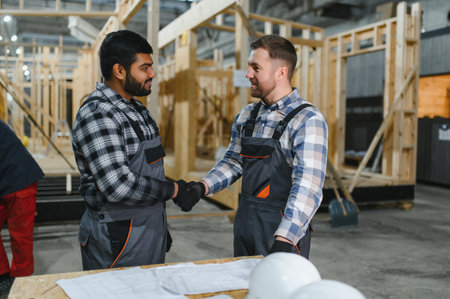 Two men are looking at a construction plan drawing or blueprint. Construction process.の写真素材