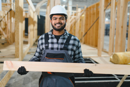 Construction of modular houses. Male Indian construction worker in uniform and hard hat at construction site.の写真素材