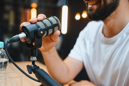 Video blogger capturing audio content with a professional condenser microphone in a well equipped...