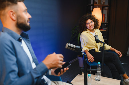 Two content creators recording a podcast episode in a professional studio, engaging in conversation...