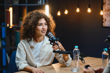 Young woman engaging with a microphone while recording a podcast in a modern professional studio,...