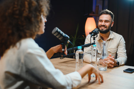 Two content creators recording a podcast episode in a professional studio, engaging in conversation...