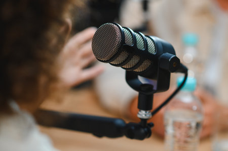 Two content creators recording a podcast using a professional microphone, discussing and gesturing