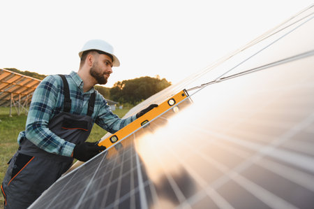 Young technician carefully installing and checking solar panel alignment, ensuring efficient,...
