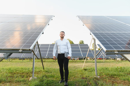 Man standing in a solar power plant, working on sustainable energy and renewable electricity...