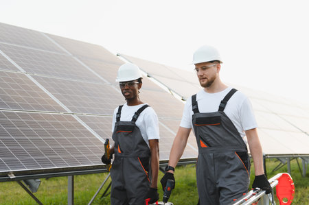 Diverse team of engineers working on renewable energy solar panels installation, promoting clean...