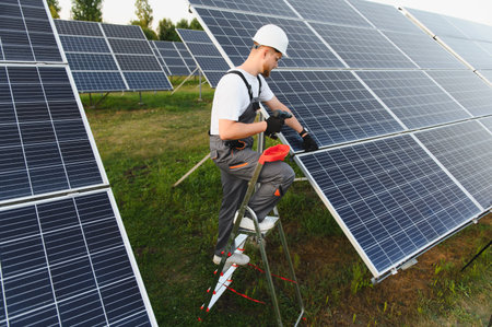 Worker in safety gear installing solar panels outdoors, contributing to sustainable electricity...