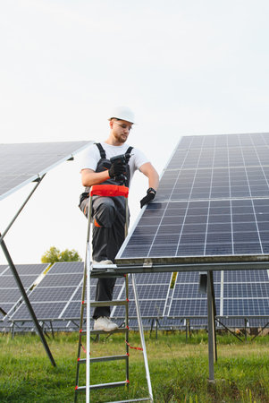 Worker on a ladder installing a solar panel. Concepts of renewable energy, sustainability, and green...