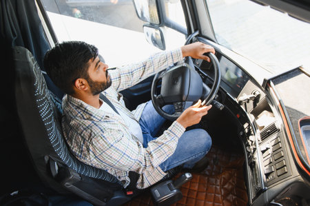 Professional male driver operating a commercial truck focusing on the road and handling the steering...