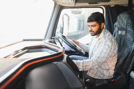 Young Indian man driving a big commercial truck, representing transport, logistics, and professional...