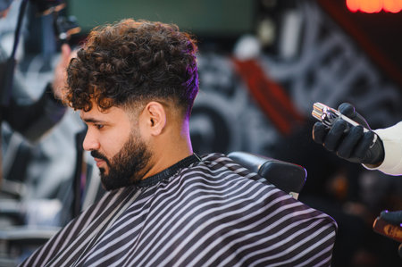 Client enjoying a professional haircut service, receiving a stylish fade and beard trim in a modern...