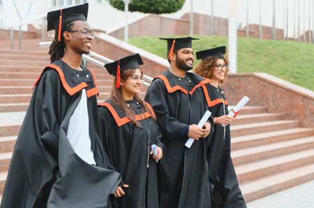Diverse college graduates proudly holding diplomas, celebrating academic success and achievement after completing their university studiesの写真素材