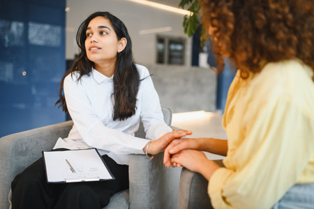 Indian female psychologist providing empathy and support to patient during mental health counseling. Focus on care and understandingの写真素材