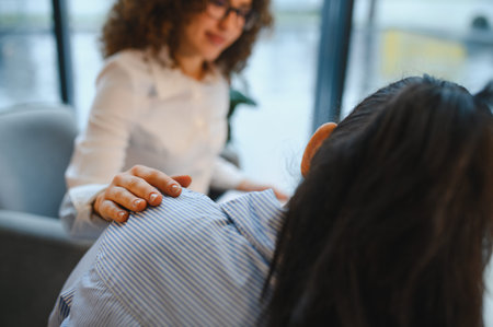 Psychologist offering comfort and support to an Indian woman patient during an individual therapy session, focusing on mental healthの写真素材