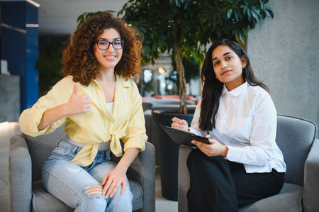 Indian woman patient showing thumbs up during a successful therapy session with her female psychologist and counselorの写真素材