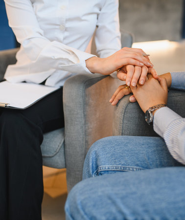 Psychologist offering comfort and empathy to a patient during a counseling session, focusing on mental health supportの写真素材