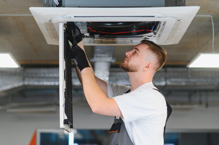 Skilled technician repairing and maintaining air conditioning system, ensuring proper climate...