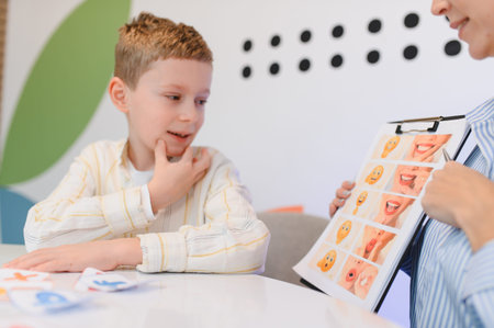 Young boy engaging in a speech therapy session, improving communication skills and emotional recognition with a specialistの写真素材