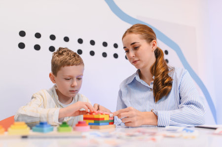 Young boy playing a developmental game with a female therapist, focusing on engaging activity for cognitive skillsの写真素材