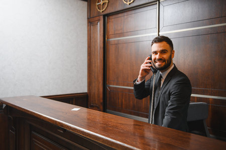 Professional man receptionist smiling, providing excellent customer service and support from a hotel...