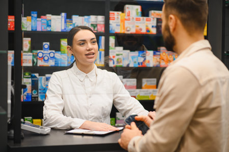 Female pharmacist communicating with a male customer at a drugstore, providing professional healthcare and medicine assistanceの写真素材