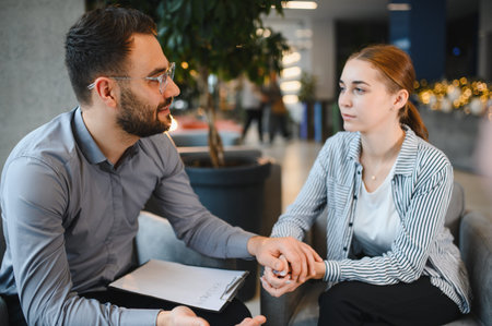 Psychologist providing emotional support and counseling to a young woman, focusing on mental health and receiving professional helpの写真素材